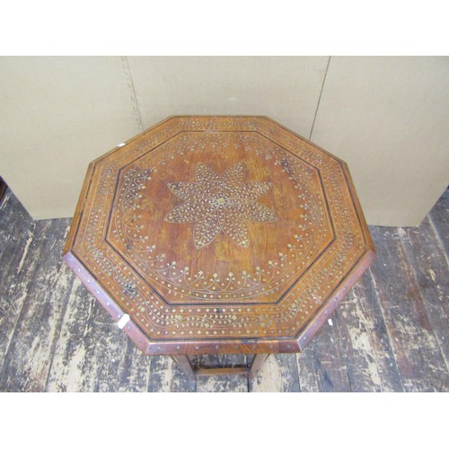 1348 - An Indian hardwood occasional table, the octagonal top with geometric brass inlay detail, raised on ... 