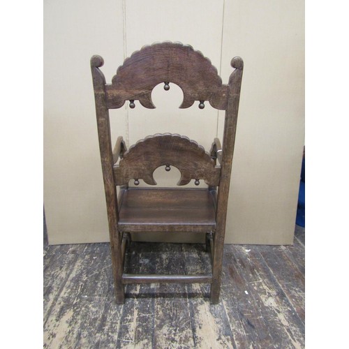 1374 - An antique oak South Yorkshire elbow chair of traditional form with carved and arched ladder back, s... 