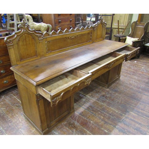 1378 - A Victorian oak sideboard with heavy Gothic influence, the base enclosed by two cupboards and three ... 