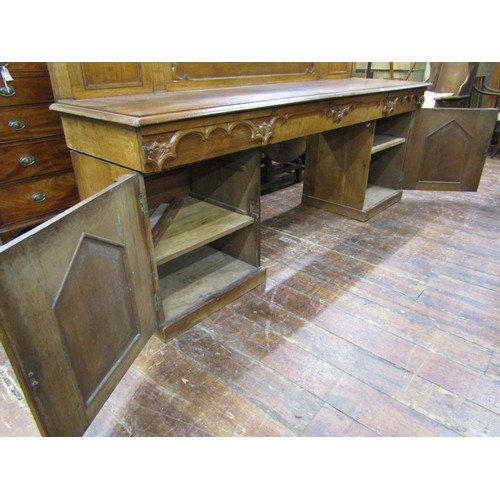 1378 - A Victorian oak sideboard with heavy Gothic influence, the base enclosed by two cupboards and three ... 