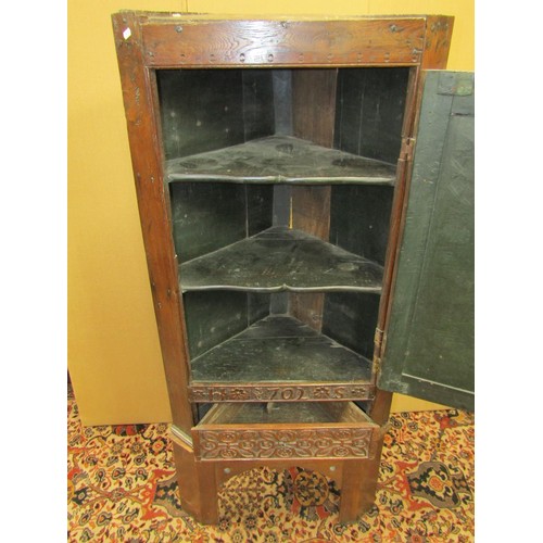 1414 - An early oak hanging corner cupboard, the carved face with geometric detail, and dated 1702, set on ... 