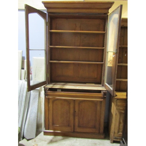 1462 - A Victorian mahogany library bookcase, the lower section enclosed by a pair of arched panelled doors... 