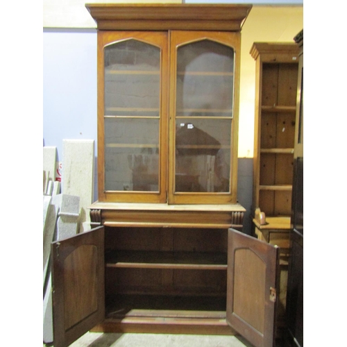 1462 - A Victorian mahogany library bookcase, the lower section enclosed by a pair of arched panelled doors... 