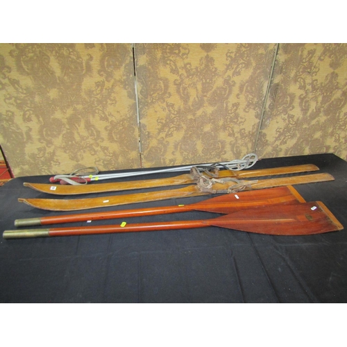 1053 - A pair of vintage ashwood skis, sticks, together with  a pair of timber oars