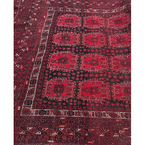 1518 - An Afghan carpet with a red and black panelled design, 260 x 200cm approximately