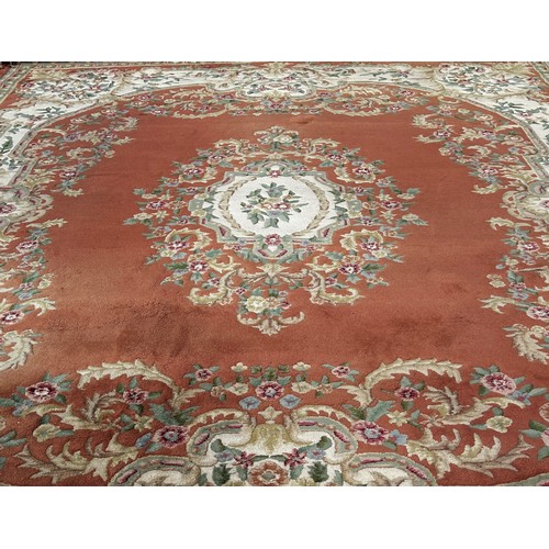 1526 - A large country house Aubusson style thick wool pile carpet with a floral medallion on an apricot fi... 