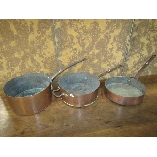 1072 - Three 19th century copper saucepans with heavy iron handles, average diameter 35cm