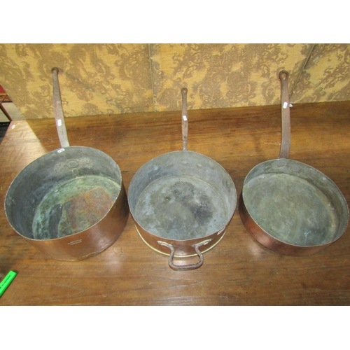 1072 - Three 19th century copper saucepans with heavy iron handles, average diameter 35cm