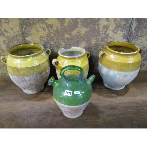 1075 - Three rustic terracotta pots with loop handles, partially glazed and a further terracotta ewer