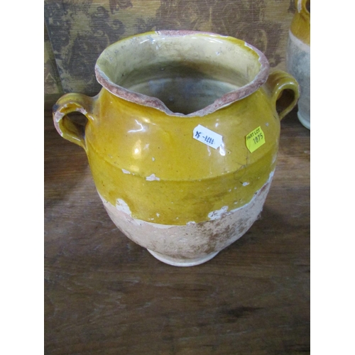 1075 - Three rustic terracotta pots with loop handles, partially glazed and a further terracotta ewer