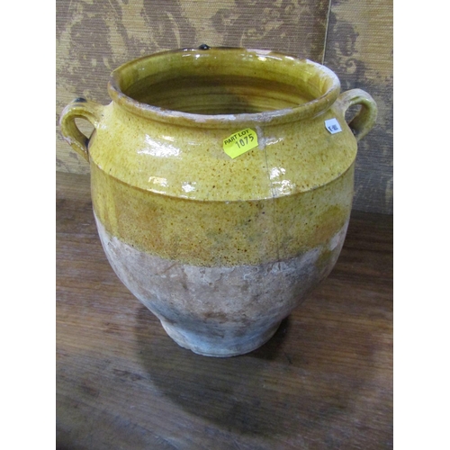 1075 - Three rustic terracotta pots with loop handles, partially glazed and a further terracotta ewer