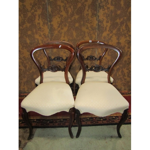 1090 - Set of four Victorian rosewood balloon back chairs with carved splats and cabriole supports