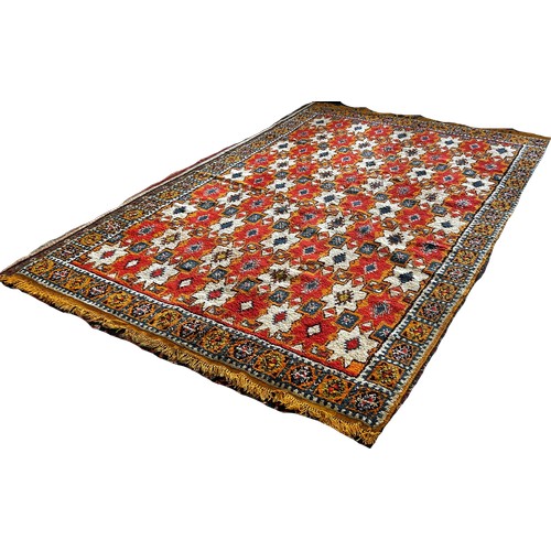 1506 - A Moroccan wool carpet with cream stars on a predominantly orange ground, 280 x 190cm approximately.