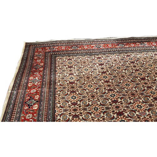 1531 - A large Middle Eastern carpet with a tight all over floral design and stylised floral borders, 410 x... 