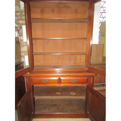 1264 - An Edwardian library bookcase in walnut, the base enclosed by a pair carved and panelled doors and t... 