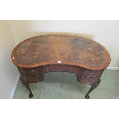 1441 - A walnut framed kneehole kidney shaped writing desk fitted with five drawers on pad feet with shell ... 