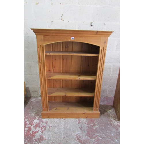 1445 - A stripped and waxed pine settle with rising lid, the panelled back within a shaped outline, 93cm wi... 