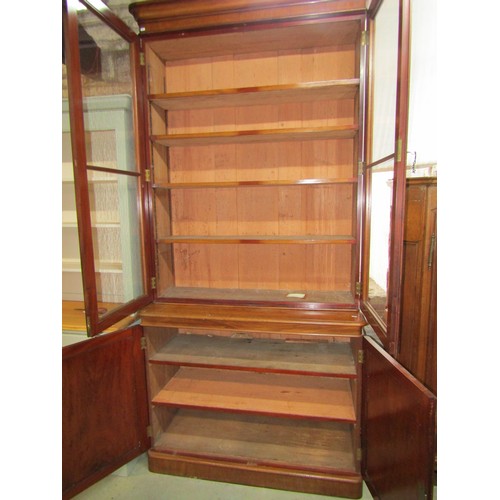 1261 - A Victorian mahogany library bookcase enclosed by a pair of arched panelled doors, the upper section... 