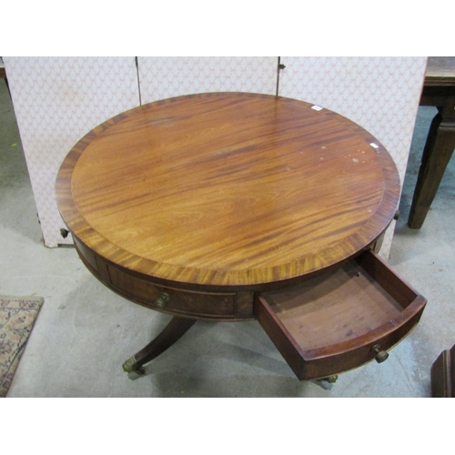 1207 - A Regency style drum table in mahogany, with alternating real and dummy drawers on turned support an... 