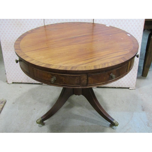 1207 - A Regency style drum table in mahogany, with alternating real and dummy drawers on turned support an... 