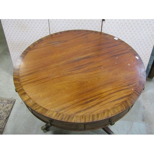 1207 - A Regency style drum table in mahogany, with alternating real and dummy drawers on turned support an... 