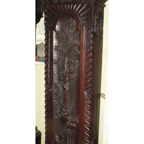 1310 - A 19th century oak longcase clock with heavy estate carving, the trunk detailing a knight fighting s... 