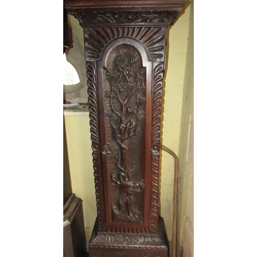 1310 - A 19th century oak longcase clock with heavy estate carving, the trunk detailing a knight fighting s... 