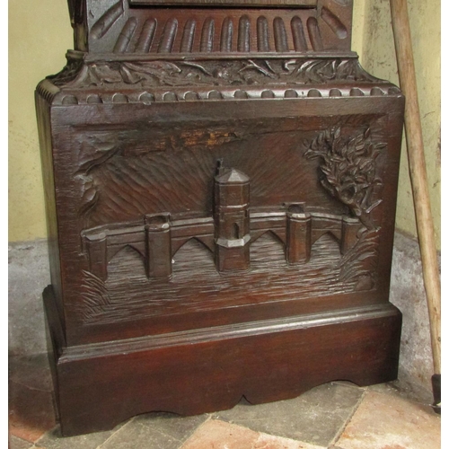 1310 - A 19th century oak longcase clock with heavy estate carving, the trunk detailing a knight fighting s... 