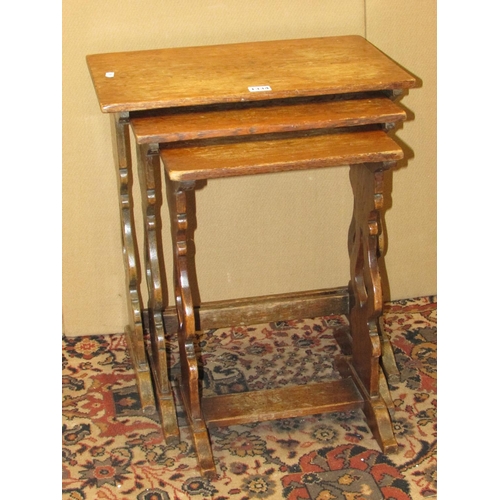 1334 - A nest of three old English style oak occasional tables with shaped supports, 46cm wide and smaller