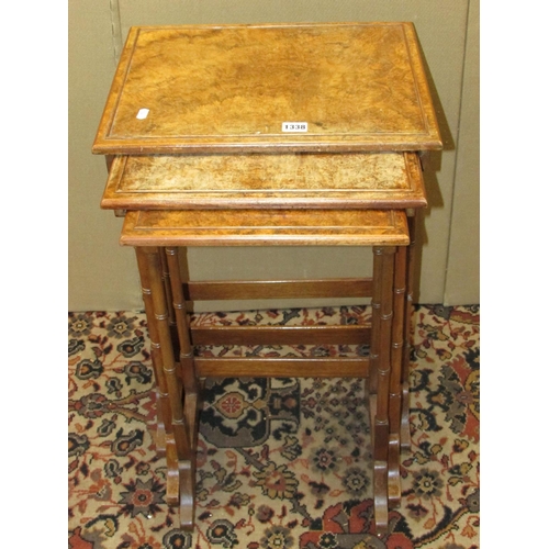 1338 - A nest of three Georgian style occasional tables, in walnut with figured walnut tops, 43cm wide max