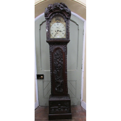 1310 - A 19th century oak longcase clock with heavy estate carving, the trunk detailing a knight fighting s... 