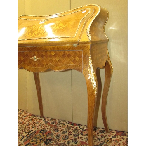 1354 - A French bureau du dame, with parquetry veneered finish, floral marquetry panel with over laid gilt ... 