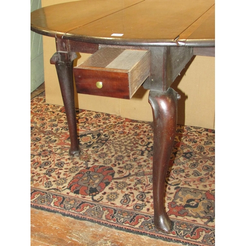 1366 - A small George III mahogany drop leaf table with frieze drawer, raised on four shaped supports with ... 