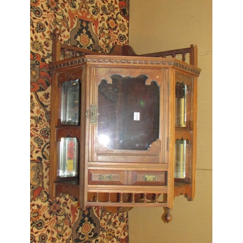 1379 - A late 19th century walnut hanging corner cupboard with mirrored recessed sides and spindle moulding... 