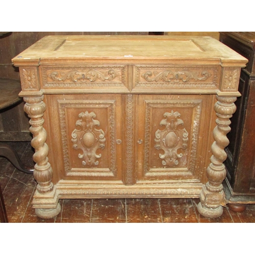 1391 - A 19th century oak side cupboard enclosed by two carved and panelled doors with two frieze drawers f... 