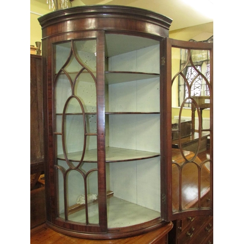 1398 - A Regency mahogany bow fronted hanging corner cupboard with astragal glazed panelled doors, original... 