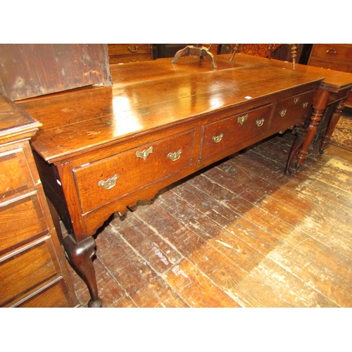 1407 - A Georgian oak dresser base fitted with three frieze drawers, shaped apron and shaped forelegs, 185c... 