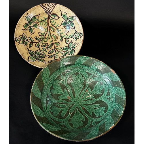 31 - Two old tin-glazed stoneware dishes, one with green foliate detail, the other with cream ground with... 