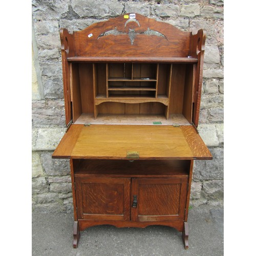 1121 - An early 20th century oak students bureau with strap hinges, the raised back with pierced detail of ... 