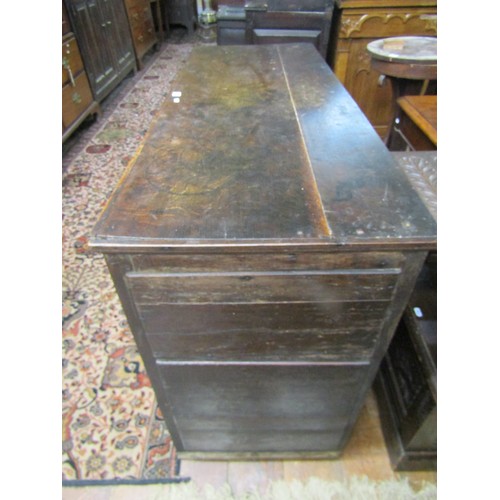 1413 - A Georgian oak dresser base with two frieze drawers and two panelled doors, with iron butterfly hing... 