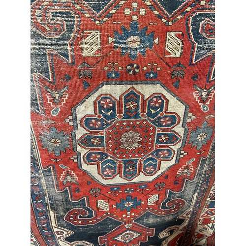 1484 - An old tribal Kazak Persian rug with an all over geometric pattern, worn in places, 204cm x 125cm ap... 