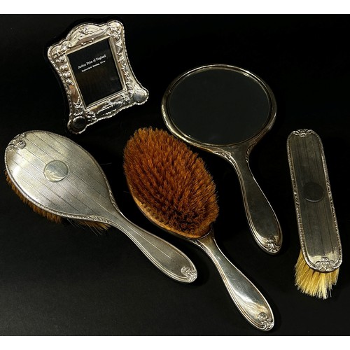 204 - A four piece silver hair brush and mirror dressing table set and a small Arthur Price photo frame, 6... 