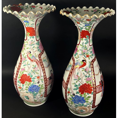 41 - A pair of Japanese export porcelain vases decorated with figures, within vignettes, with floral bord... 