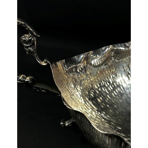 232 - A twin handled boat shaped silver dish with a hand finished worked surface, stamped do Silver Smith ... 