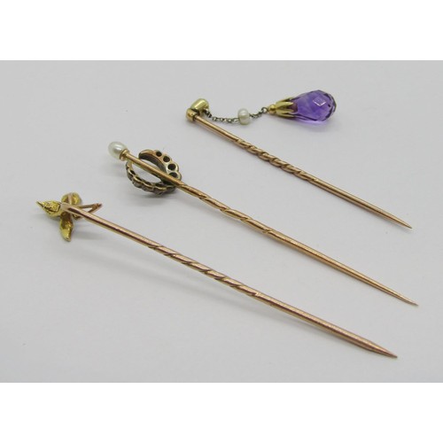 299 - Three antique stick pins comprising an Art Nouveau 9ct example with 15ct pearl set terminal, a yello... 