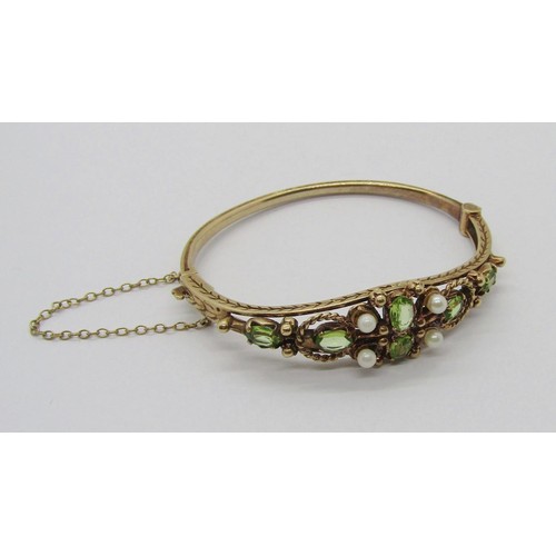 300 - Antique style 9ct peridot and pearl hinged bangle, with engraved herringbone detail, 17.8g