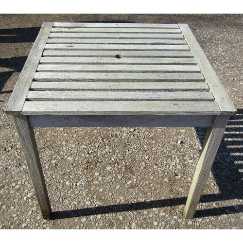 1005 - A weathered (silvered) teak garden suite comprising a folding bench with slatted seat and back 141 c... 