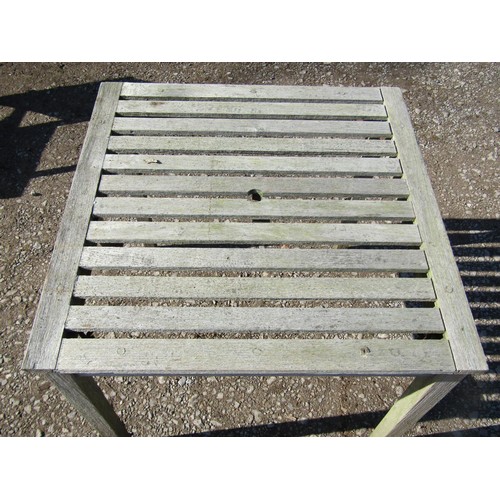 1005 - A weathered (silvered) teak garden suite comprising a folding bench with slatted seat and back 141 c... 