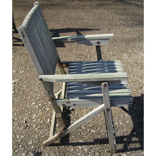 1005 - A weathered (silvered) teak garden suite comprising a folding bench with slatted seat and back 141 c... 