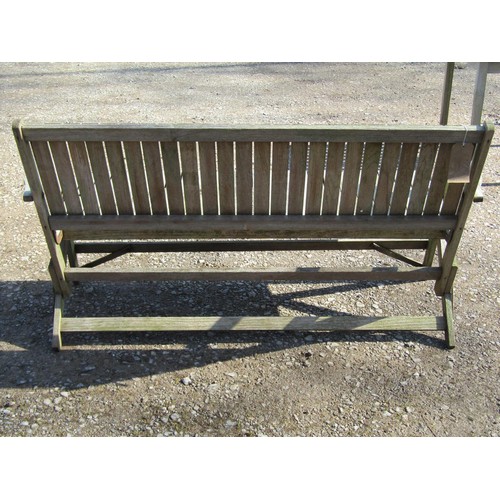 1005 - A weathered (silvered) teak garden suite comprising a folding bench with slatted seat and back 141 c... 